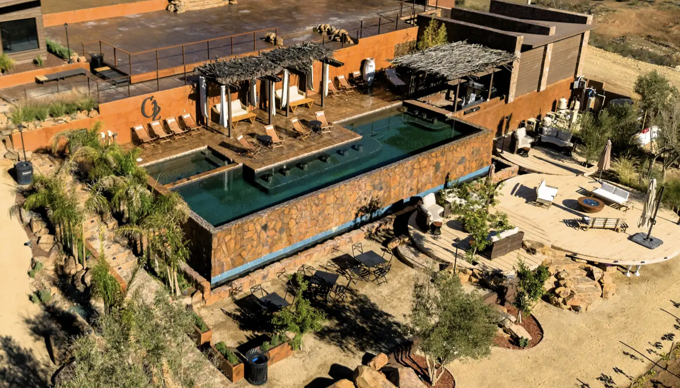 Aerial drone view of the pool at O2 Resort Valle de Guadalupe surrounded by the scenic landscape of Baja California wine country