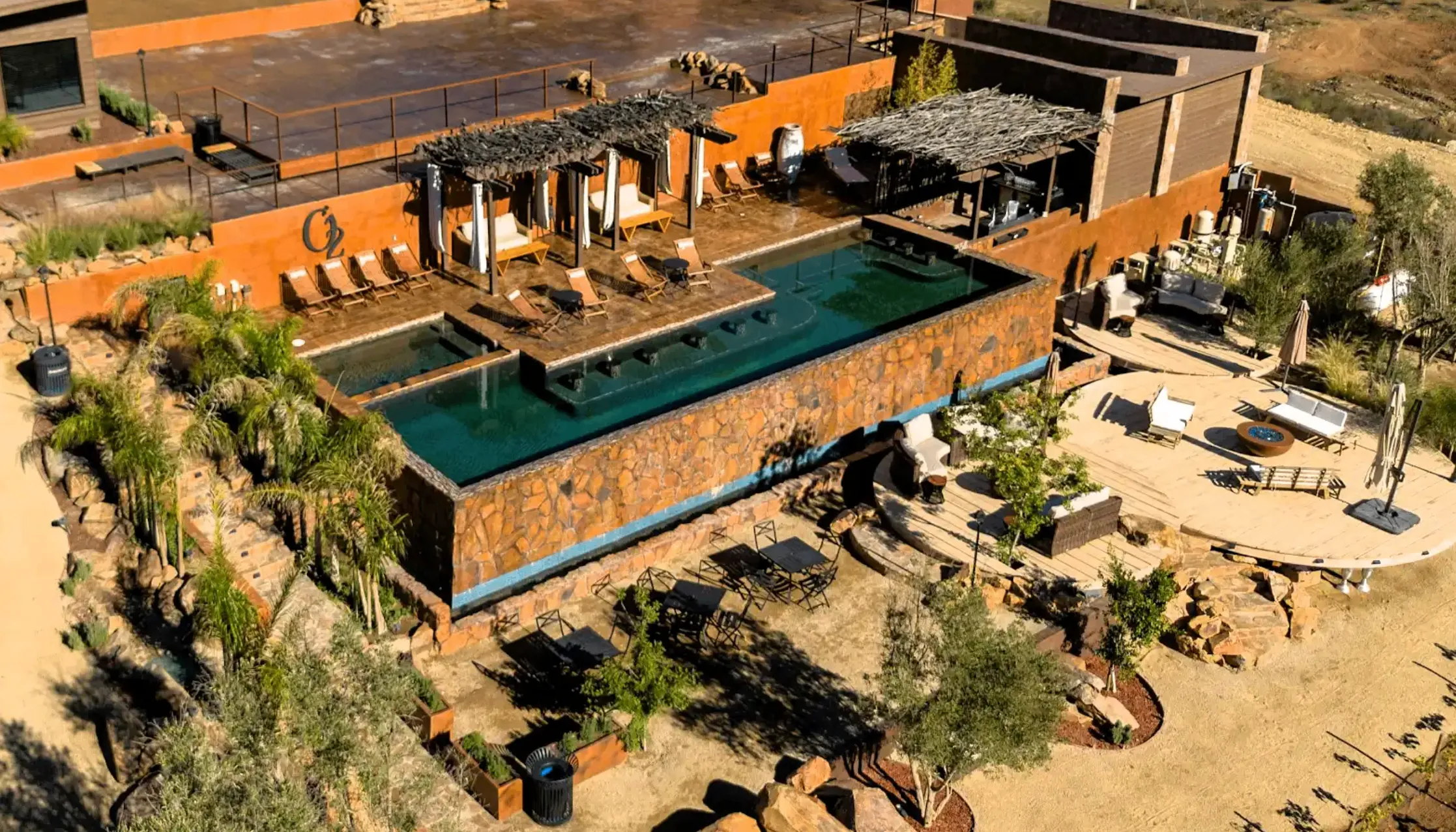 Aerial drone view of the pool at O2 Resort Valle de Guadalupe surrounded by the scenic landscape of Baja California wine country