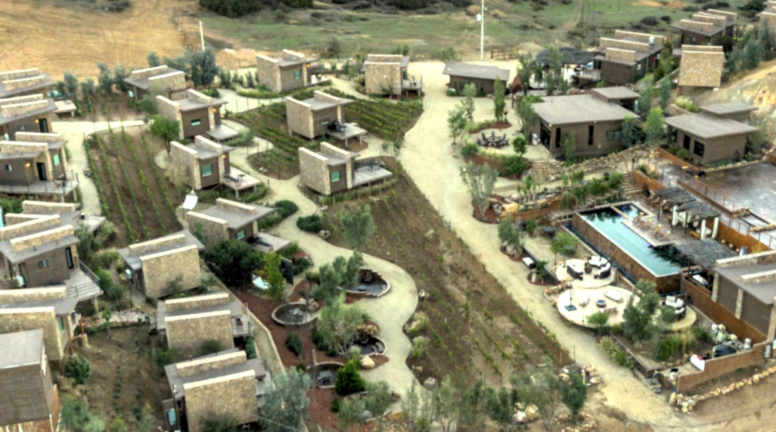 Aerial drone view of O2 Resort Valle de Guadalupe showing the resort cabins surrounded by the natural landscape of Baja California wine country