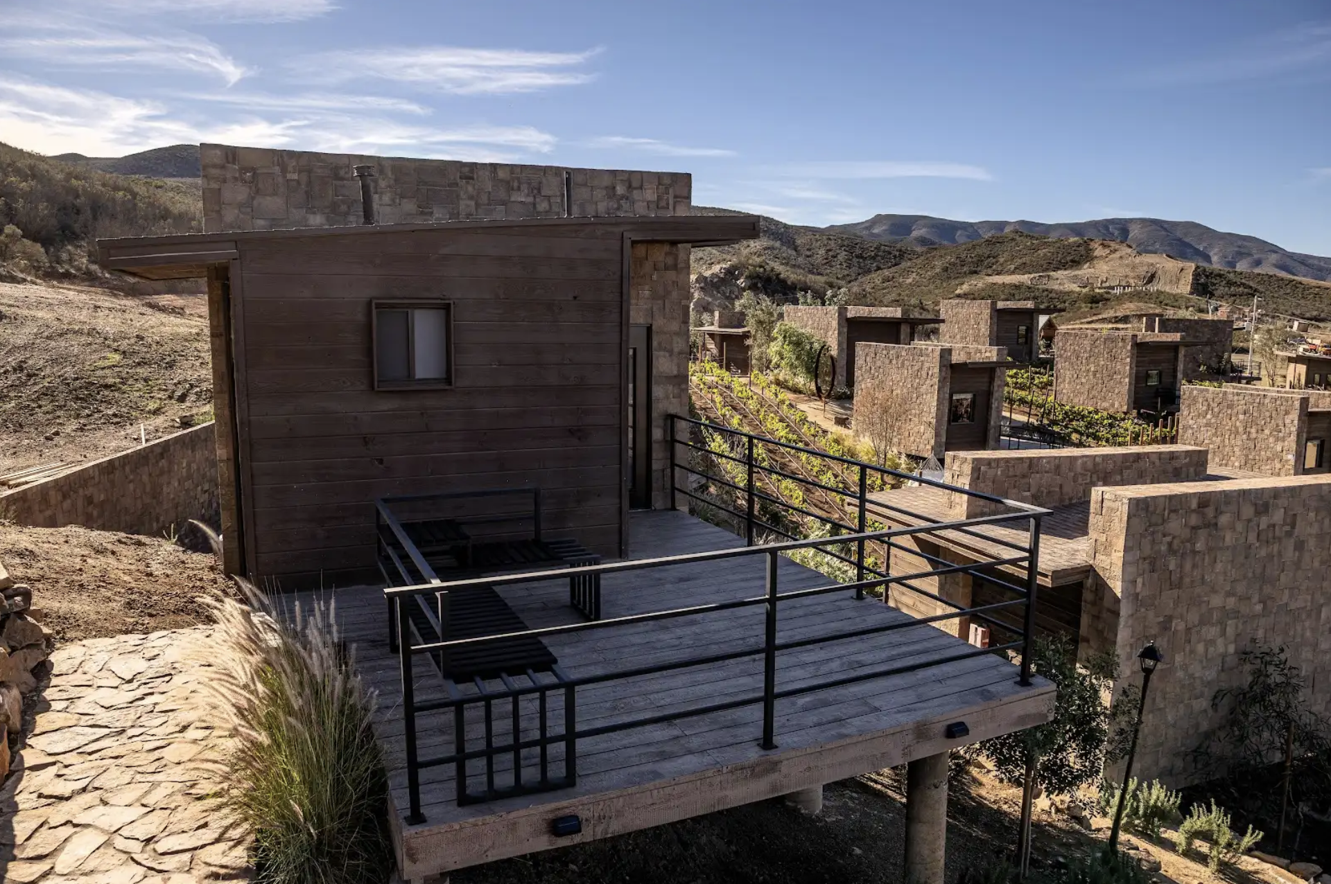 Exterior view of a luxury cabin at O2 Resort Valle de Guadalupe surrounded by the natural landscape of Baja California wine country